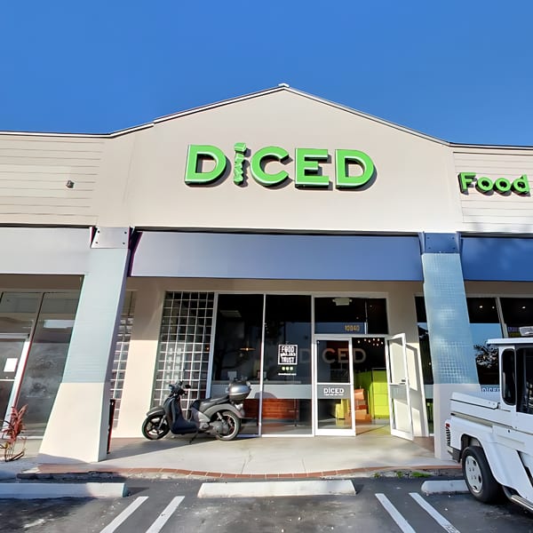 Exterior of Diced restaurant with green signage, a scooter, and a white truck parked outside.