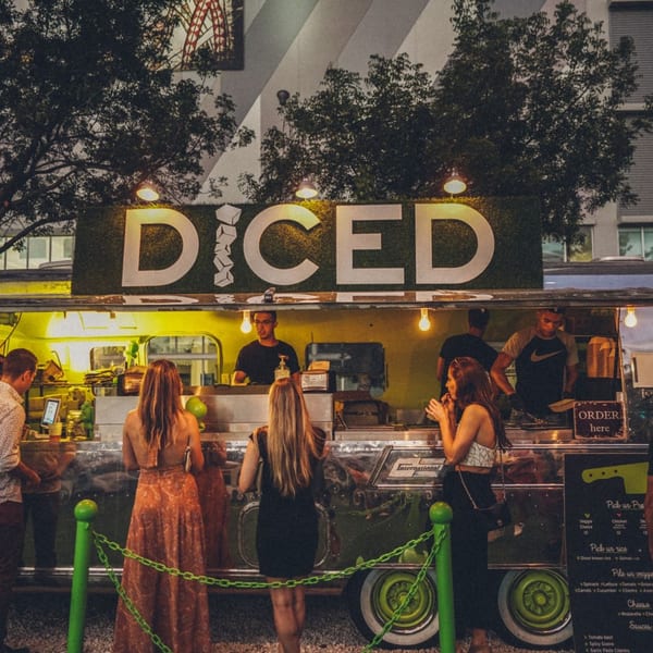 Customers order from the Diced food truck at night, illuminated by warm lights.