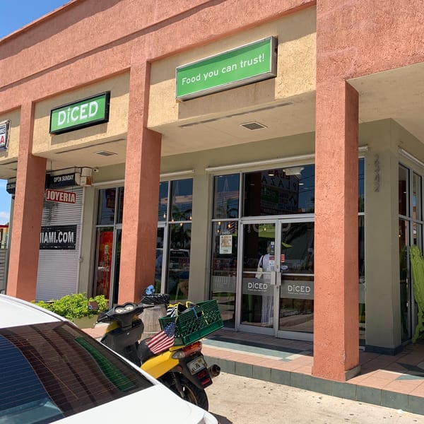 Exterior of Diced restaurant with a green sign, glass doors, and a scooter parked outside.